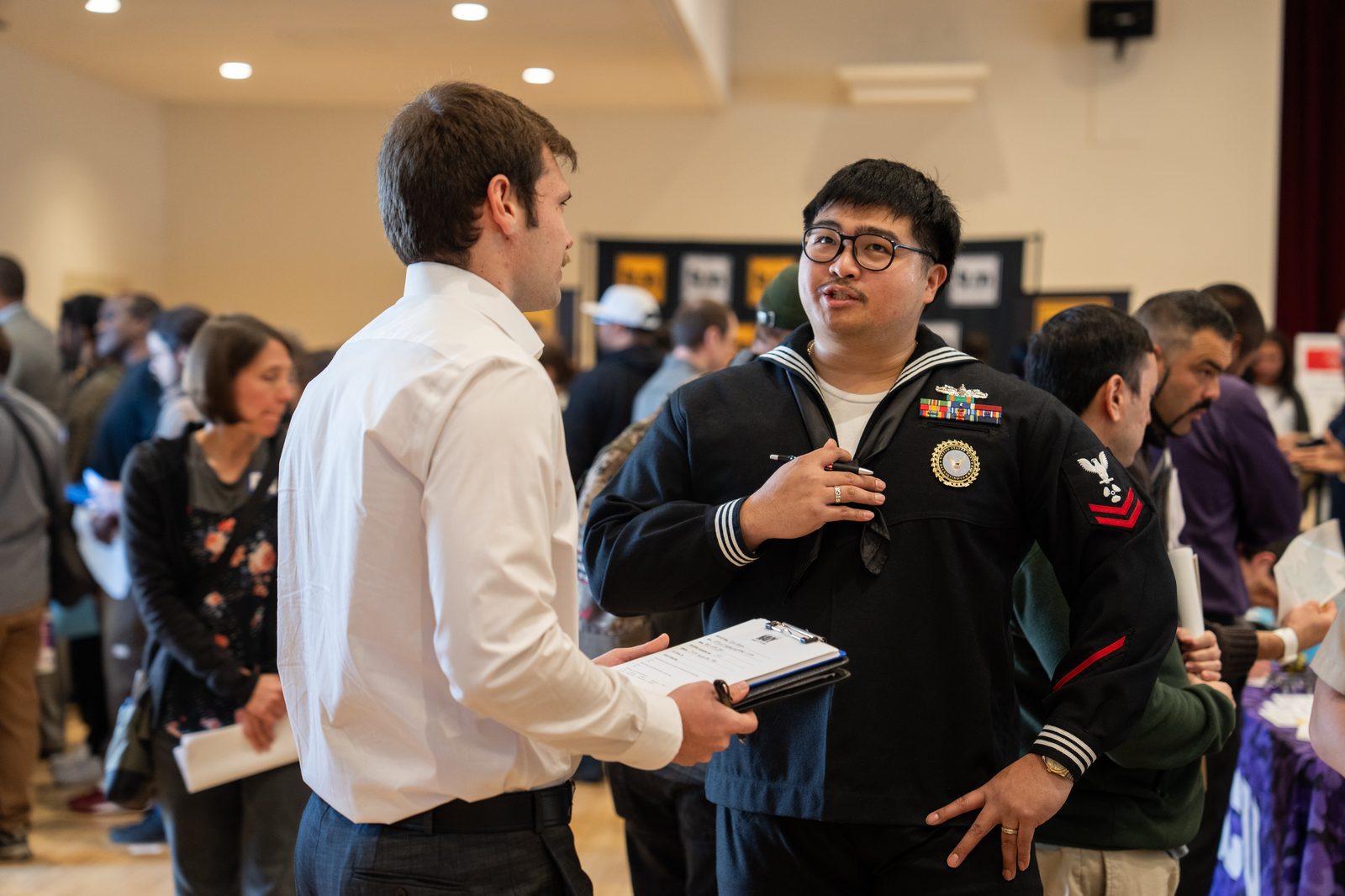 U.S. Navy sailor speaking with a recruiter at SacJobs Career Fair