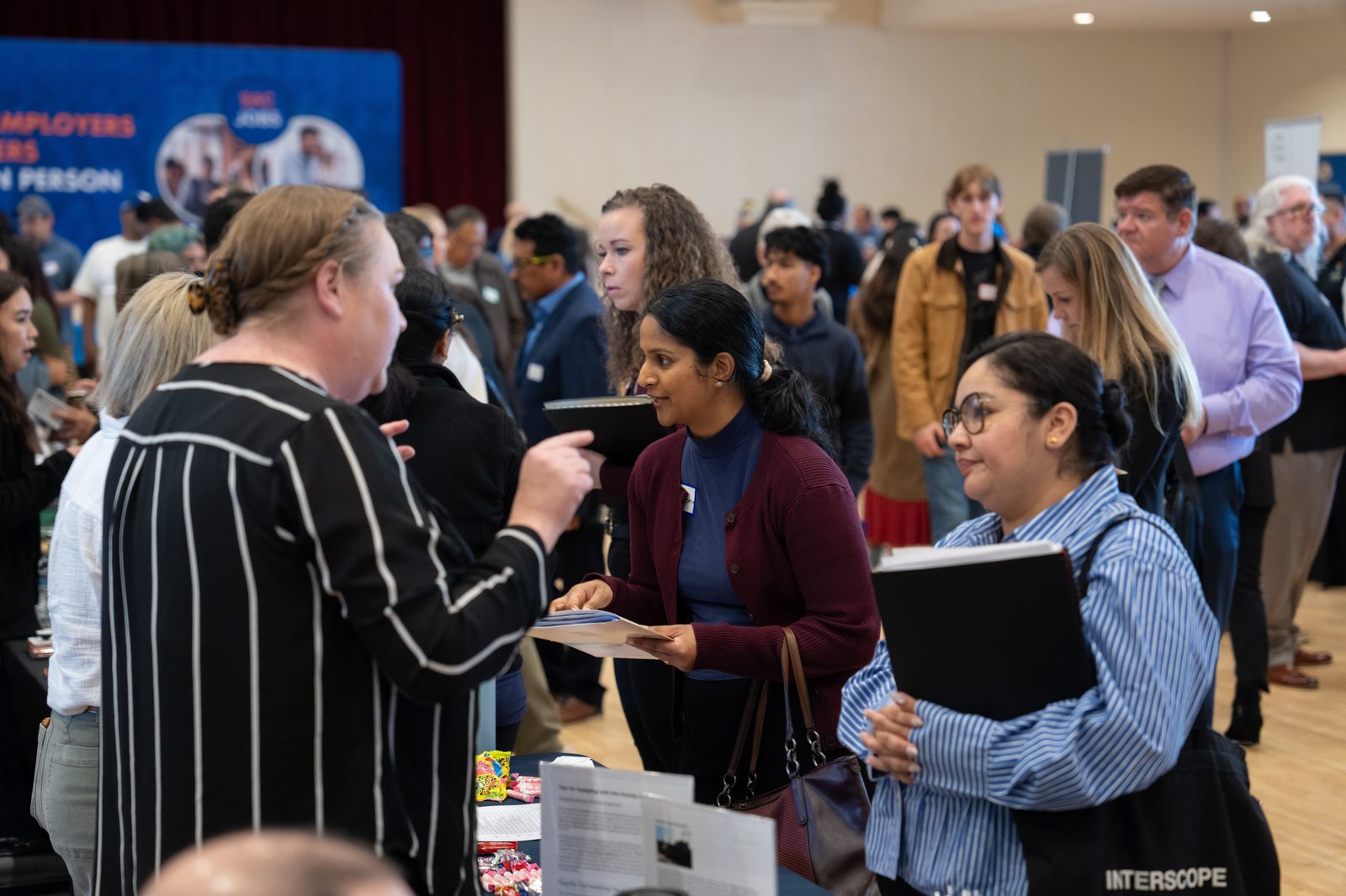 Multiple job seekers engaging with employers at SacJobs Career Fair